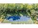 View of community tennis court showing the playing surface surrounded by mature trees at 13610 S Village Dr # 4212, Tampa, FL 33618