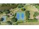 Aerial view of community tennis and basketball courts surrounded by lush landscaping and a walking path at 13610 S Village Dr # 4212, Tampa, FL 33618