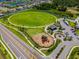 This aerial view features a large open field, a playground, a parking lot, and walking trails at 13622 Tonya Anne Dr, Riverview, FL 33579