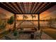 Backyard patio with lounge seating overlooks picturesque water view and tropical landscaping at sunset at 13622 Tonya Anne Dr, Riverview, FL 33579