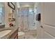 This bathroom features a granite vanity, a shower-tub combo, and a patterned shower curtain at 13622 Tonya Anne Dr, Riverview, FL 33579