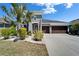 Gray two-story home featuring a three-car garage, well-kept lawn and attractive desert-style landscaping at 13622 Tonya Anne Dr, Riverview, FL 33579