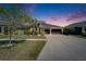 Well-manicured lawn with beautiful landscaping leading up to this gray, two-story home with a three-car garage at 13622 Tonya Anne Dr, Riverview, FL 33579