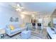 Open-concept living room with ceiling fan, modern décor, and seamless flow to the kitchen at 13870 Oakwood Ln # 13870, Seminole, FL 33776