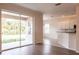 Living space with wood-look floors, sliding glass doors to the lanai, and a kitchen view at 1430 Blue Horizon Cir, Bradenton, FL 34208