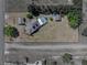 Overhead shot showing a home with a pool, outbuildings, and expansive yard bordered by roads and lush trees at 14721 Scharber Rd, Dade City, FL 33525
