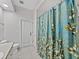 Bathroom featuring a patterned shower curtain and tile flooring at 14721 Scharber Rd, Dade City, FL 33525