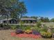 Home surrounded by landscaped garden beds, vibrant flowers, and a well-maintained lawn at 14721 Scharber Rd, Dade City, FL 33525