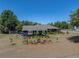Landscaped front yard with colorful flower beds and a detached garage at 14721 Scharber Rd, Dade City, FL 33525