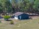 Detached garage featuring a covered carport and landscaping at 14721 Scharber Rd, Dade City, FL 33525