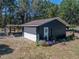 Detached garage featuring a carport and flower garden with a wreath on the door at 14721 Scharber Rd, Dade City, FL 33525