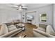 Spacious living room featuring wood-look floors, neutral furnishings, a ceiling fan, and lots of natural light at 14721 Scharber Rd, Dade City, FL 33525