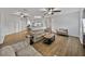Open-concept living room with wood-look flooring, ceiling fans, and neutral-toned furniture at 14721 Scharber Rd, Dade City, FL 33525