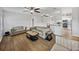Bright, open living area with wood floors, neutral furniture, a ceiling fan, and a view of the kitchen at 14721 Scharber Rd, Dade City, FL 33525