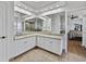 Bathroom vanity with dual sinks and a large mirror with shower and bedroom view at 14721 Scharber Rd, Dade City, FL 33525