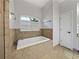 Bright and airy main bathroom features a soaking tub with tile surround at 14721 Scharber Rd, Dade City, FL 33525