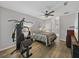 Relaxing main bedroom features exercise equipment, ensuite access, ceiling fan, and wood-look floors at 14721 Scharber Rd, Dade City, FL 33525