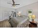 Bright main bedroom features exercise equipment, two windows, French doors, ceiling fan, and wood-look floors at 14721 Scharber Rd, Dade City, FL 33525
