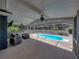 Covered patio features a seating area and a view of the pool at 14721 Scharber Rd, Dade City, FL 33525