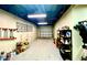 Spacious basement featuring concrete block walls, shelving units for storage, and a steel roll-up garage door at 1644 Scott St, Clearwater, FL 33755