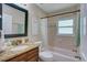 Well-lit bathroom with a tub and shower, vanity, and neutral tile flooring at 1644 Scott St, Clearwater, FL 33755