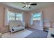 Cozy bedroom featuring a ceiling fan, natural light, and neutral colored carpet at 1644 Scott St, Clearwater, FL 33755