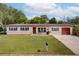 Charming single-story home featuring a well-maintained lawn, neutral paint, and a neatly manicured landscape at 1644 Scott St, Clearwater, FL 33755