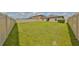 Lush green backyard enclosed by a pristine white fence, offering a private outdoor space at 16665 Delia St, Wimauma, FL 33598
