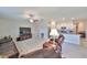 Open-concept living room with a ceiling fan connected to the kitchen featuring stainless appliances at 16665 Delia St, Wimauma, FL 33598