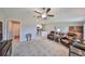 Open layout living room with tile floors, a ceiling fan, and flows to kitchen area at 16665 Delia St, Wimauma, FL 33598