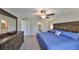 This main bedroom features wood furnishings, a ceiling fan, and access to the main bathroom at 16665 Delia St, Wimauma, FL 33598