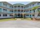 Beautiful condo building with lovely landscaping, light blue railings, and a light-filled entryway at 1950 59Th N Ave # 208, St Petersburg, FL 33714