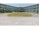 Lovely condo building with well-kept landscaping, circular driveway, and blue balcony railings at 1950 59Th N Ave # 208, St Petersburg, FL 33714