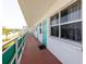 Long, outdoor condo hallway with multiple windows, a tile floor, and white walls at 1950 59Th N Ave # 208, St Petersburg, FL 33714