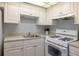 Functional kitchen offering white appliances, plenty of cabinets, and a neutral countertop at 1950 59Th N Ave # 208, St Petersburg, FL 33714