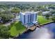 Aerial view of a waterfront apartment complex featuring a pool, dock, tennis court, and parking spaces at 2780 N Riverside Dr # 802, Tampa, FL 33602