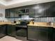 Modern kitchen featuring black cabinets, granite countertops, and stainless steel appliances at 2780 N Riverside Dr # 802, Tampa, FL 33602