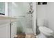 Bathroom featuring a white shower with glass door, a white vanity and toilet at 3212 E Henry Ave, Tampa, FL 33610