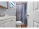 Bathroom showcasing white vanity, toilet, and shower with black and white curtain at 3212 E Henry Ave, Tampa, FL 33610