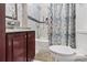 Bathroom featuring a tub with shower curtain, a wood vanity and toilet at 3212 E Henry Ave, Tampa, FL 33610