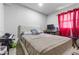 Comfortable bedroom features an upholstered headboard and a window with red curtains at 3212 E Henry Ave, Tampa, FL 33610
