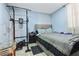 Bedroom with light blue walls, neutral bedding, and exercise equipment, offering a functional space at 3212 E Henry Ave, Tampa, FL 33610
