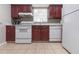 Galley kitchen featuring ample counter space, a window, tile backsplash and major white appliances at 3212 E Henry Ave, Tampa, FL 33610