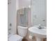 This well-lit bathroom features a pedestal sink, shower and tub combination, and neutral tiling at 36 Gulf Blvd # 3, Indian Rocks Beach, FL 33785