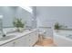 Bright bathroom features double vanity, jacuzzi tub, neutral tile, and clean, white cabinets at 36 Gulf Blvd # 3, Indian Rocks Beach, FL 33785
