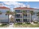 Three story condo building featuring balconies, red tile roof and palm trees at 36 Gulf Blvd # 3, Indian Rocks Beach, FL 33785