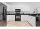 Kitchen with stainless steel appliances, black countertops, and ample white cabinet storage at 36 Gulf Blvd # 3, Indian Rocks Beach, FL 33785