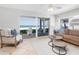 Comfortable living room with tile floors, ceiling fan, couch, and sliding glass doors to the patio with beach views at 36 Gulf Blvd # 3, Indian Rocks Beach, FL 33785