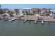 Charming waterfront homes with private docks lining a scenic coastal street enhanced by palm trees at 36 Gulf Blvd # 3, Indian Rocks Beach, FL 33785