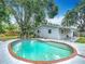 Backyard pool with blue tile is surrounded by lush landscaping, creating a private and serene oasis at 3702 W Reynolds St, Plant City, FL 33563